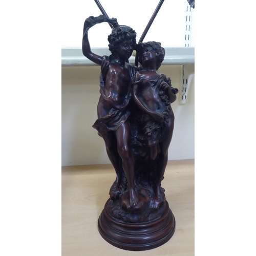 259 - A 20thC composition bronze effect table lamp, fashioned as two children, on a plinth  31