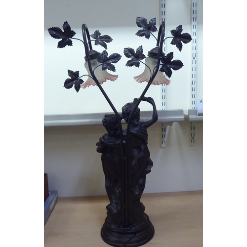 259 - A 20thC composition bronze effect table lamp, fashioned as two children, on a plinth  31