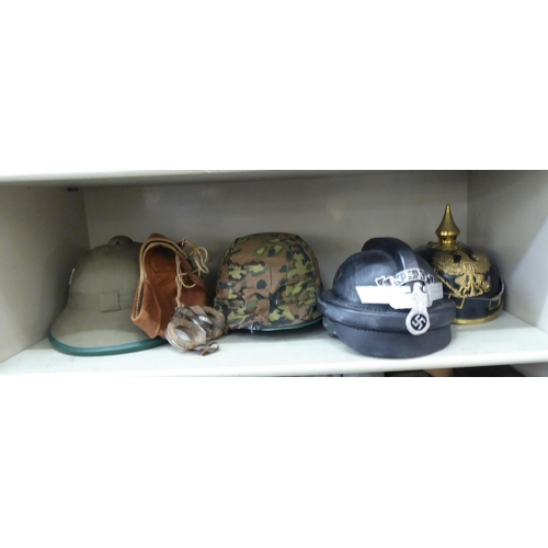 269 - Military and associated headgear: to include a German Third Reich pith helmet; a black lacquered and... 