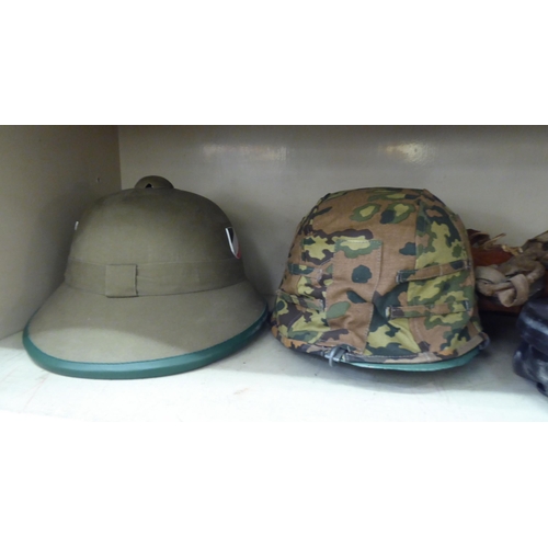 269 - Military and associated headgear: to include a German Third Reich pith helmet; a black lacquered and... 