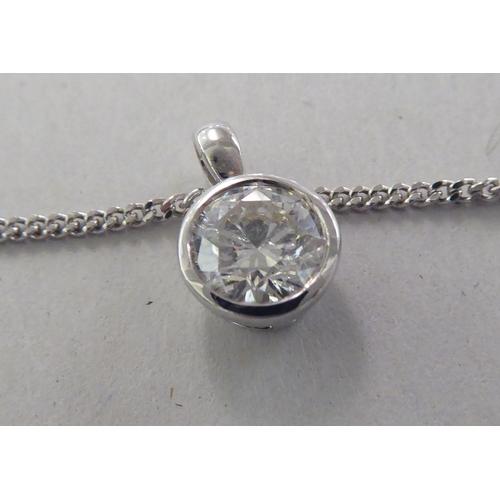 A white gold pendant, set with a single diamond, on a fine neckchain