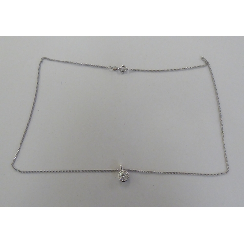 A white gold pendant, set with a single diamond, on a fine neckchain