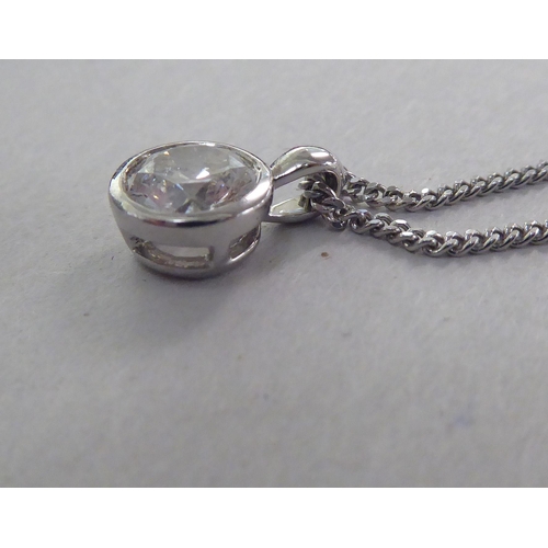 A white gold pendant, set with a single diamond, on a fine neckchain