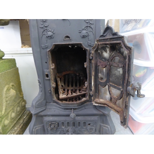 369 - An early 20thC cast iron wood burning stove, decorated in relief with flora, on a bracket plinth&nbs... 