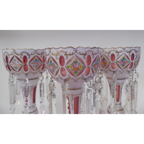 37 - A set of three late 19thC Continental cranberry coloured glass lustre vases with overlaid white and ... 