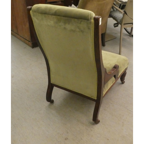 387 - An Edwardian mahogany showwood framed nursing chair, later part button upholstered in green fabric, ... 