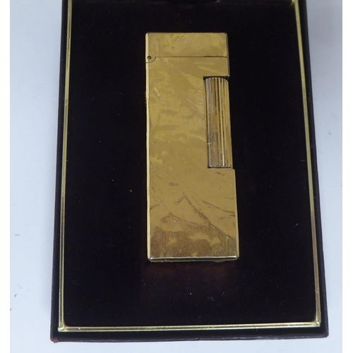 438 - Two similar Dunhill textured gold plated cased flip-top, gas filled cigarette lighters  one box... 