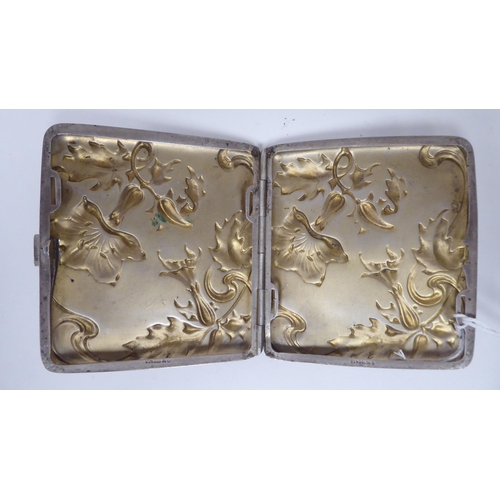 439 - An Art Nouveau silver coloured metal folding cigarette case, on a button clasp, decorated with cast ... 