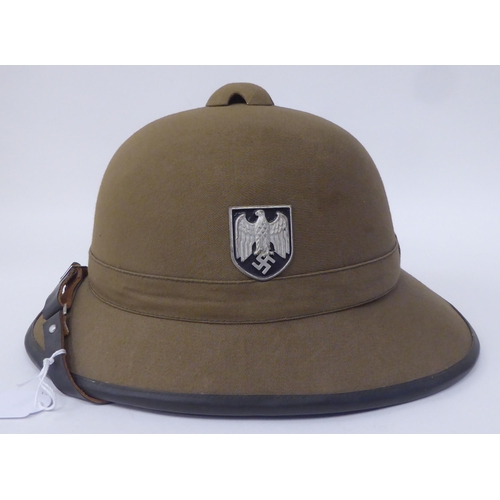 47 - A Royal Welsh Fusiliers, Hawkes & Co khaki coloured pith helmet and liner; a similar German helm... 