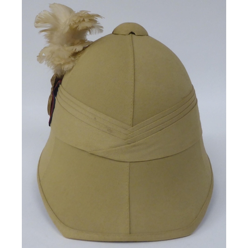 47 - A Royal Welsh Fusiliers, Hawkes & Co khaki coloured pith helmet and liner; a similar German helm... 