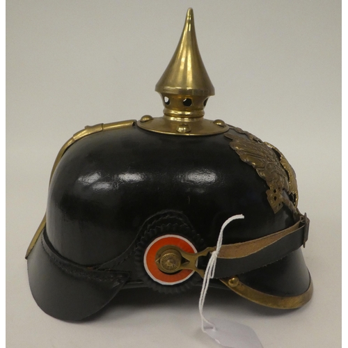 48 - A German black hide and brass mounted pickelhaube with a liner(Please Note: this lot is subject to t... 