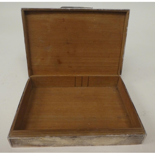 49 - A silver cigarette box with a flush fitting hinge to the engine turned lid, enclosing a cedar lined ... 