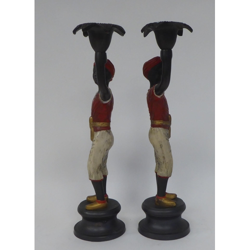 5 - A pair of Victorian style cast and part painted bronze blackamoor figures, each holding aloft a flor... 