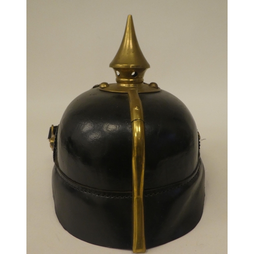 59 - A German black hide and brass mounted pickelhaube with a liner(Please Note: this lot is subject to t... 