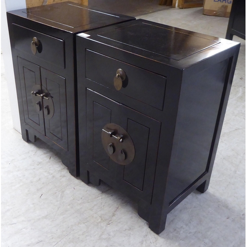 67 - A pair of modern Japanese inspired black painted bedside chests, each with a single drawer, over two... 