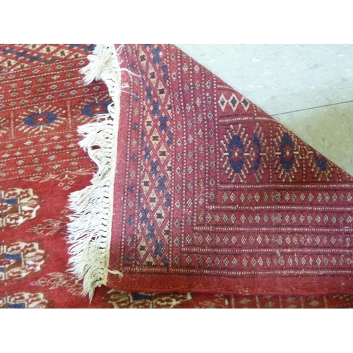 84 - A Bokhara rug, decorated with three columns of twenty guls, on a red ground  50