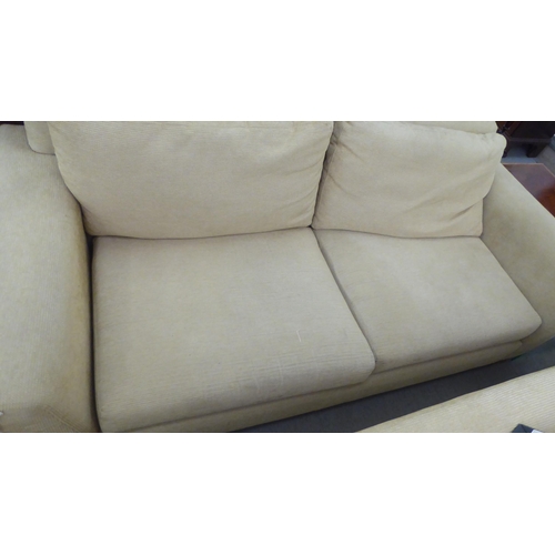 71 - A modern two person settee, upholstered in oatmeal coloured fabric with a level back and arms, raise... 