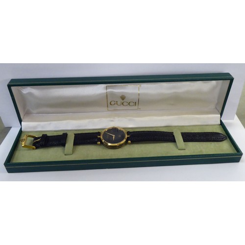 245 - A ladies Gucci black and yellow metal cased wristwatch, on a dedicated black lizard leather strap, b... 