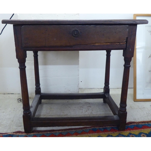 107 - A George III oak single drawer side table, raised on turned and block legs  25