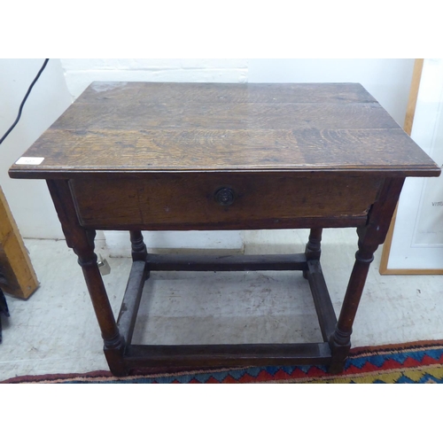 107 - A George III oak single drawer side table, raised on turned and block legs  25