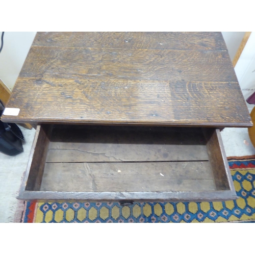 107 - A George III oak single drawer side table, raised on turned and block legs  25