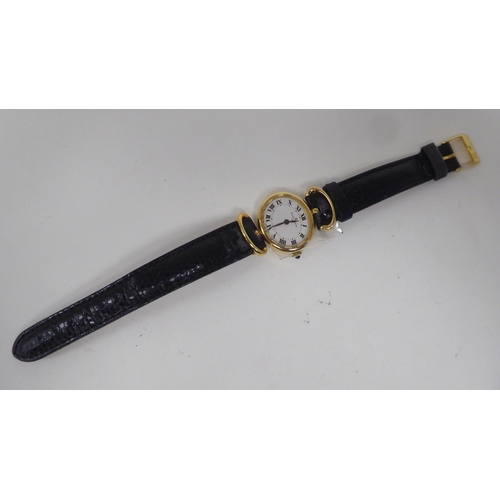 109 - A lady's Baume & Mercia 18ct gold oval cased wristwatch, on a black hide strap