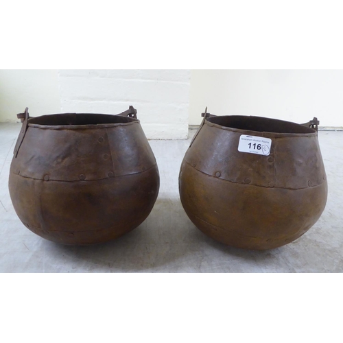 116 - A pair of rivetted cast metal hanging cooking pots