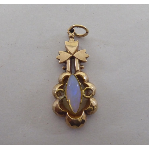 124 - A yellow metal pendant, set with a central opal, featuring a floral motif  stamped 9ct