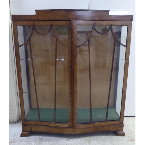 134 - An Art Deco walnut finished display cabinet, raised on bracket feet  48