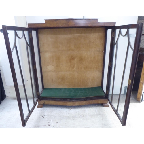 134 - An Art Deco walnut finished display cabinet, raised on bracket feet  48