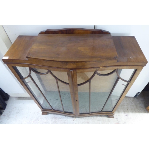 134 - An Art Deco walnut finished display cabinet, raised on bracket feet  48