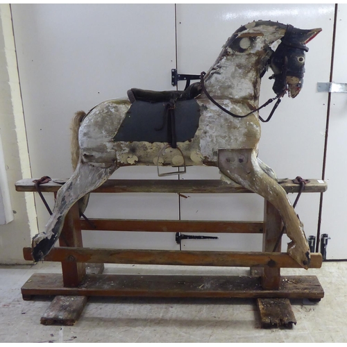 182 - An early 20thC overpainted, hand carved, pine rocking horse  50