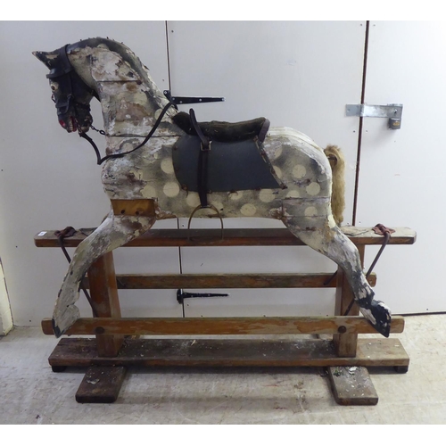 182 - An early 20thC overpainted, hand carved, pine rocking horse  50