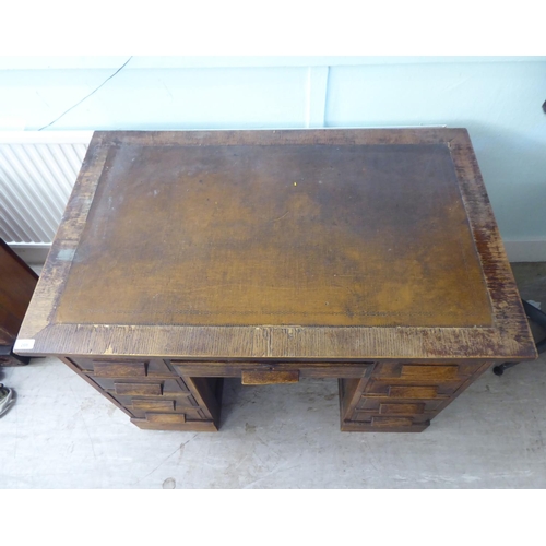 208 - A 1930s oak veneered one piece, nine drawer twin pedestal desk, on a plinth  30