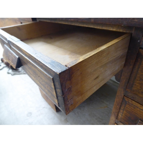 208 - A 1930s oak veneered one piece, nine drawer twin pedestal desk, on a plinth  30