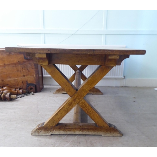 212 - A late 19thC oak refectory table, the planked top over a pair of crossover supports and platform fee... 