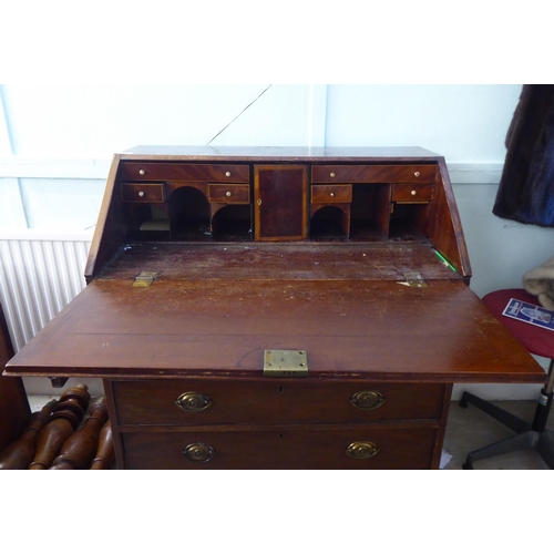 220 - A George III mahogany bureau with a fall flap, over four graduated drawers, raised on bracket feet&n... 