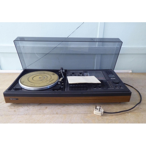 221 - A Garrard GAI55 audio system, in a teak effect and tinted plastic hinged case  30.5