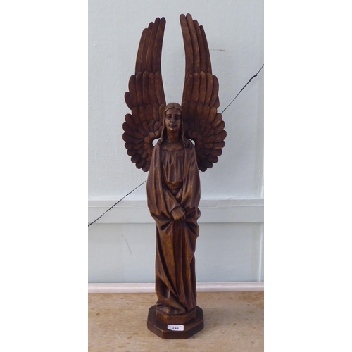 241 - A 20thC carved oak figure, a standing angel with outspread wings, on an octagonal plinth  29