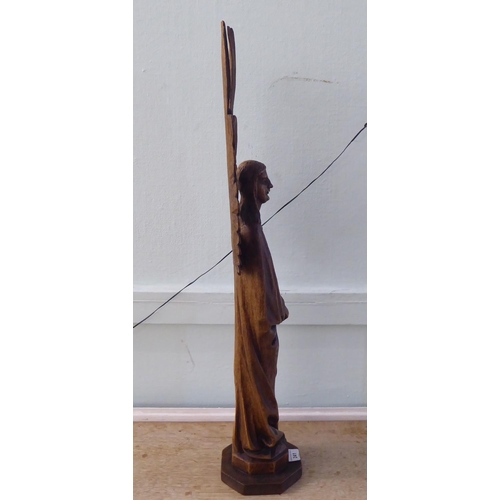 241 - A 20thC carved oak figure, a standing angel with outspread wings, on an octagonal plinth  29