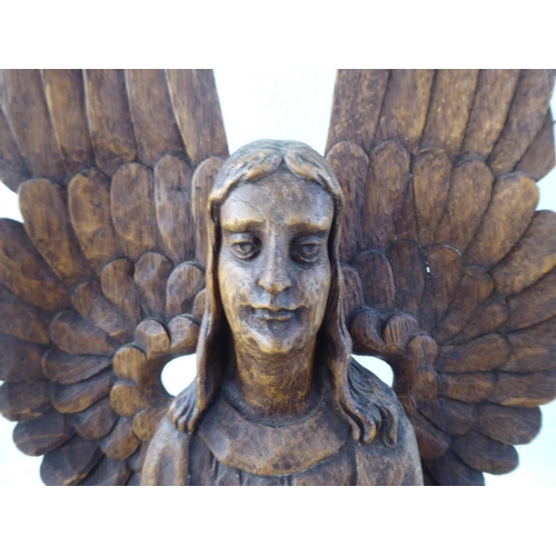 241 - A 20thC carved oak figure, a standing angel with outspread wings, on an octagonal plinth  29