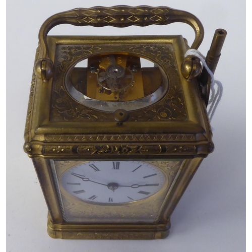 268 - An early 20thC (probably French) lacquered and ornately engraved brass and glazed carriage timepiece... 