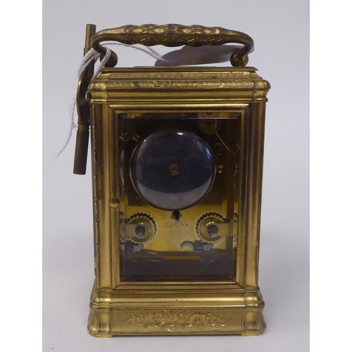 268 - An early 20thC (probably French) lacquered and ornately engraved brass and glazed carriage timepiece... 