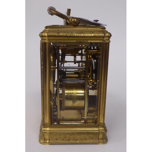 268 - An early 20thC (probably French) lacquered and ornately engraved brass and glazed carriage timepiece... 