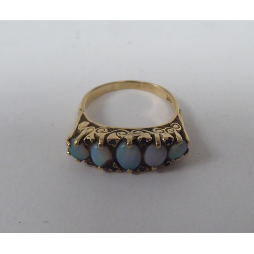 274 - A late Victorian yellow metal ring, set with five graduated opals  stamped 9ct 