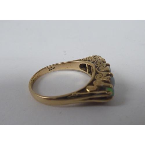 274 - A late Victorian yellow metal ring, set with five graduated opals  stamped 9ct 