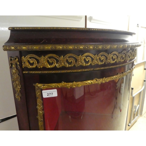 277 - A 20thC reproduction of an 18thC European inspired stained beech corner vitrine with gilt metal moun... 