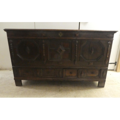 280 - A late 18thC oak coffer with straight sides and a hinged lid, a panelled front and two drawers, rais... 