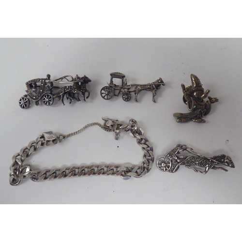 300 - Silver and white metal jewellery: to include a charm bracelet; and various broochs 