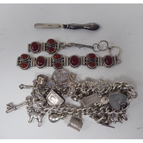 300 - Silver and white metal jewellery: to include a charm bracelet; and various broochs 